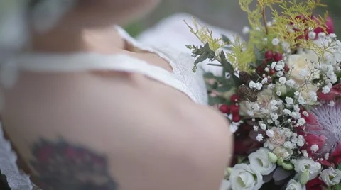 Bride with a tattoo on her back and holding flowers Stock Footage 61264607