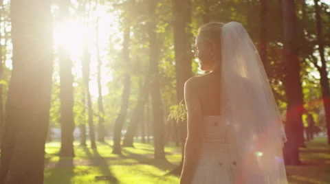 Bride is throwing a flower bouquet at wedding in a sunny park Stock Footage