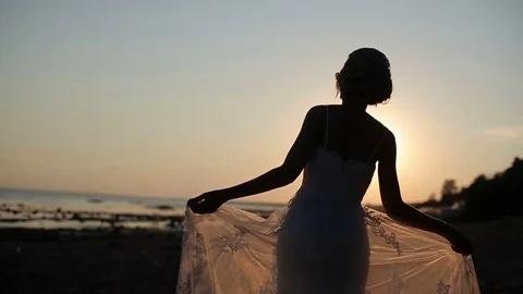 Bride walking on a evening beach Stock Footage 72324308