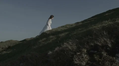 Bride walking up windy hill v2 Stock Footage 38848754