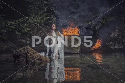 Bride in water near fire Stock Photos