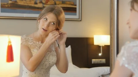 The bride Wears Earrings in front of a Mirror Stock Footage 123514227