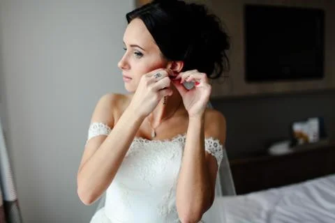 The bride wears earrings Stock Photos