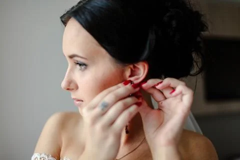 The bride wears earrings Stock Photos
