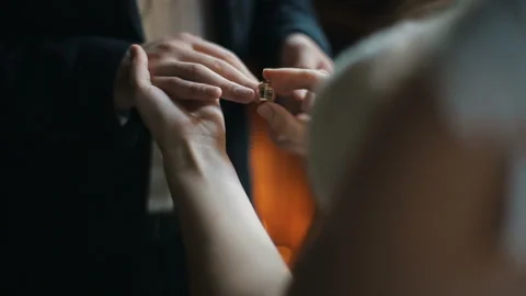 Bride wears ring on groom's finger. The bride and groom exchange wedding rings. 库存影片 87568091