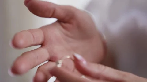 The bride wears wedding ring on her finger before the wedding. Close up Stock Footage 211398593