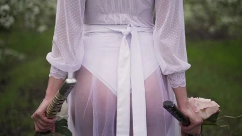 Bride in white clothes walks through the garden Stock Footage 157429977