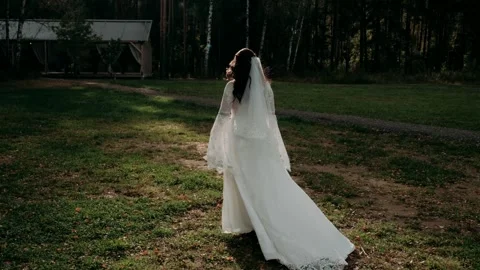 The bride in a white dress goes into the forest	 Stock Footage 320261153