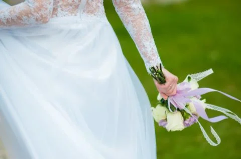 Bride in a white dress holds a wedding bouquet Stock Photos