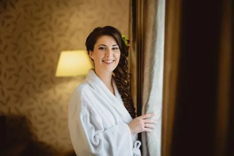 Bride in a white lab coat standing near window Stock Photos