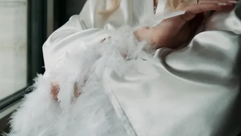 Bride in a white silk robe with feathers on the sleeves Stock Footage 320229960