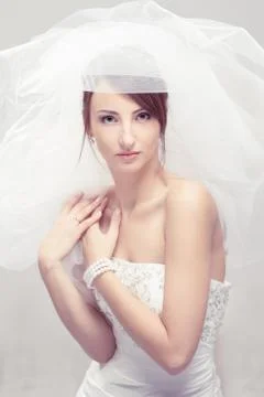 Bride in white veil looking at camera. Portrait. Fashion wedding shot. Stock Photos