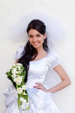 Bride by the white wall looking up Stock Photos