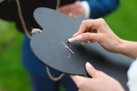 Bride writes with chalk on a board 스톡 사진