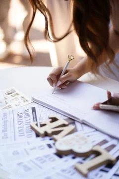 Bride writes a message in a wedding guestbook with a diamond decorated pen, c Stock Photos