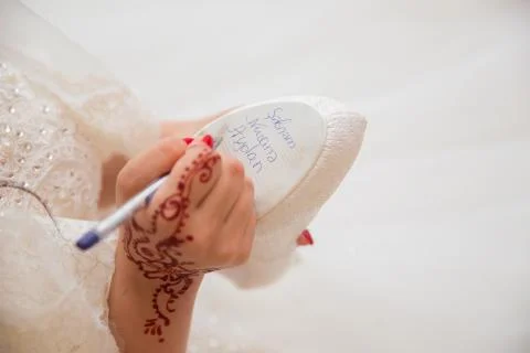 Bride writes under shoe wedding ritual superstition . hand of a bride writing Stock Photos
