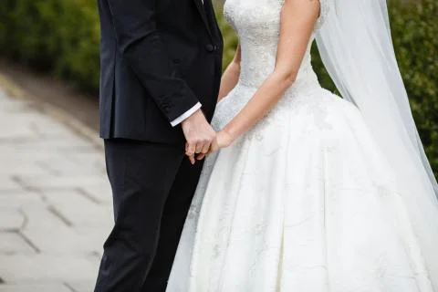 The bridegroom keeps the bride by hand Stock Photos