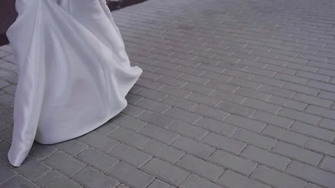 A brides dress flutters as she walks, slow motion video Stock Footage 329248317