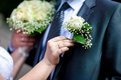 The bride's hand with a ring adjusts the buttonhole. wedding Stock Photos