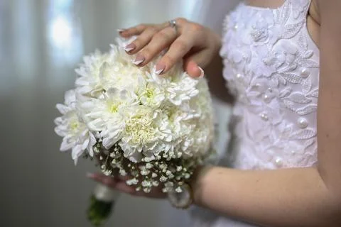 Bride's hand touching her delicate wedding bouquet Stockfoto's