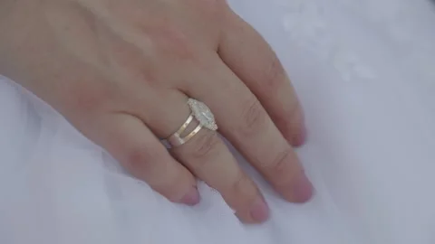 Bride's Hand on White Wedding Dress Displays Engagement and Wedding Rings Stock Footage 344090400