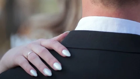 The bride's hands gently embrace the groom by the shoulders and stroke him Stock Footage 90892166