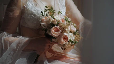 The bride's hands hold a round wedding bouquet of ivory roses. Stock Footage 104759693