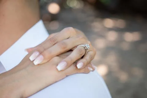 Brides hands with wedding ring around grooms shoulders. Wedding concept Foto stock