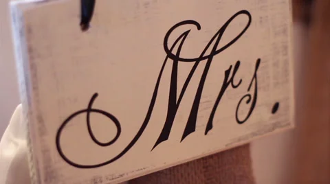 Bride's "Mrs." wedding reception rustic sign pan and rack focus Video stock 33996083