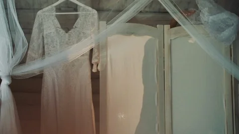 Bride's Shadow Behind The Screen. White Dress On The Hanger. Video stock 108630197