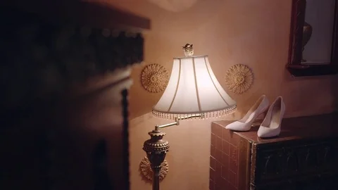 Bride's shoes. Standing on the table. Background light wall. Around a floor lamp Video stock 85039928