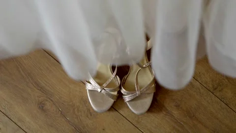 The bride's shoes standing under the wedding dress, waiting for the time of the Stock Footage 296324501