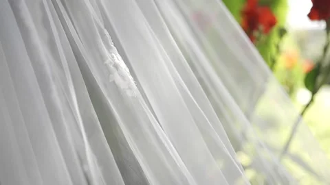 A bride's veil flowing gently in the breeze against a natural outdoor backdrop Stock-Footage 304985326