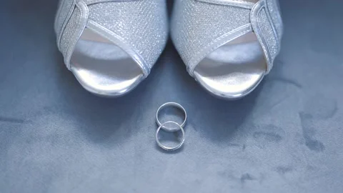 A bride's wedding ring next to her shoes Stock Footage 150996877