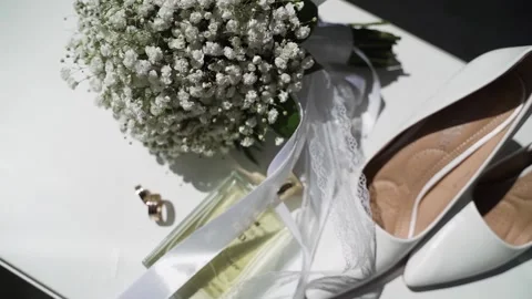 Bride's white shoes, perfume bottle and gypsophila bouquet Stock Footage 172192512