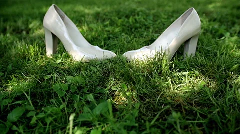 Bride's white wedding shoes in the grass. Stock Footage 65727094
