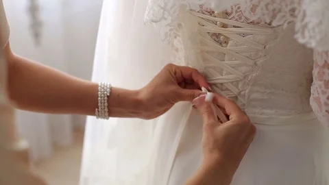 Bridesmaid is helping the bride to dress,close-up. Stock Footage