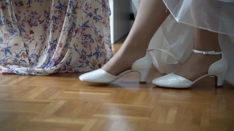 Bridesmaid helping the bride to put on her shoes Stock Footage 239733898