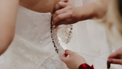 Bridesmaid helping for young bride to put on her wedding dress Stock Footage 132697261