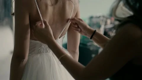 Bridesmaid helps the bride get dressed on the day of the wedding. Video stock 221924693