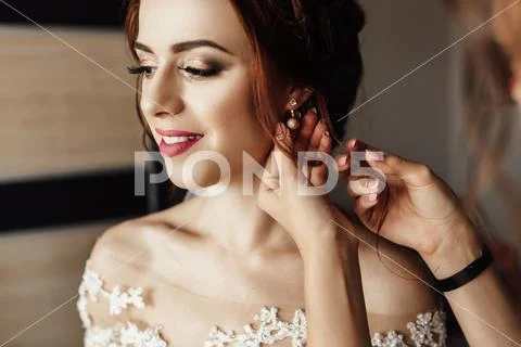 Bridesmaids whirl bride's veil while she smiles Stock Photos