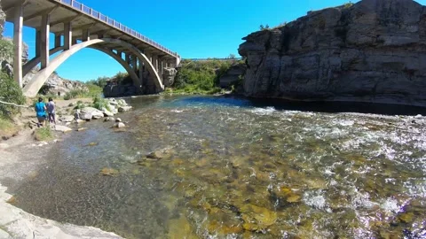 Bridge with an arch over the shallow river on a blue sky day. 스톡 동영상 152991440