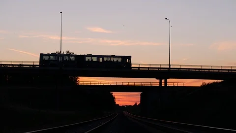 Bridge Below Railroad Tracks At Dawn, Bus Silhouette Drives By Stock Footage 91032086
