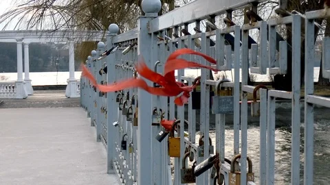 Bridge in the city park with locks. In the wind red ribbon Stock Footage 105092290