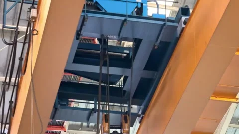 Bridge crane running on elevated rails inside a factory building. Stock Footage 337723821