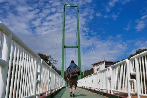 Bridge crossing with hiking backpack Stock Photos
