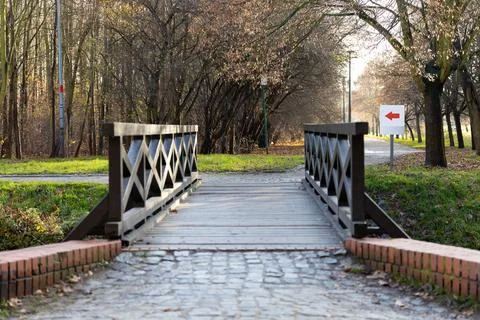 Bridge crossing over a cobblestone path in a quiet wooded area Stock Photos