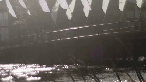 Bridge with Flags over gently flowing river Video stock 83183976