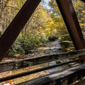 Bridge Frames Fall Colors Along Creek Stock Photos