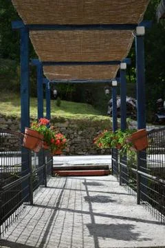 Bridge with geraniums on the stream Stock Photos